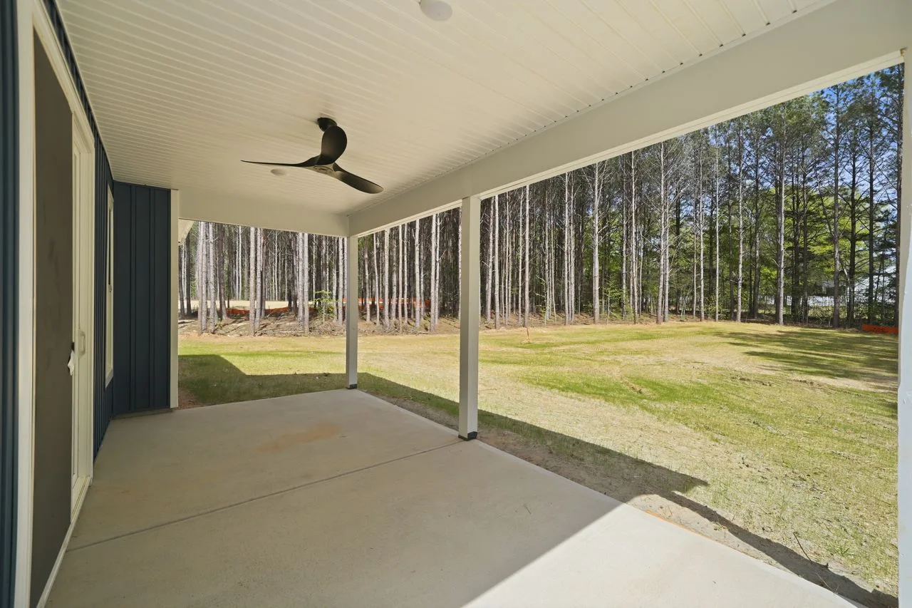 Covered rear porch with ceiling fan overlooking wooded backyard — 1412 Quiver Way, York SC