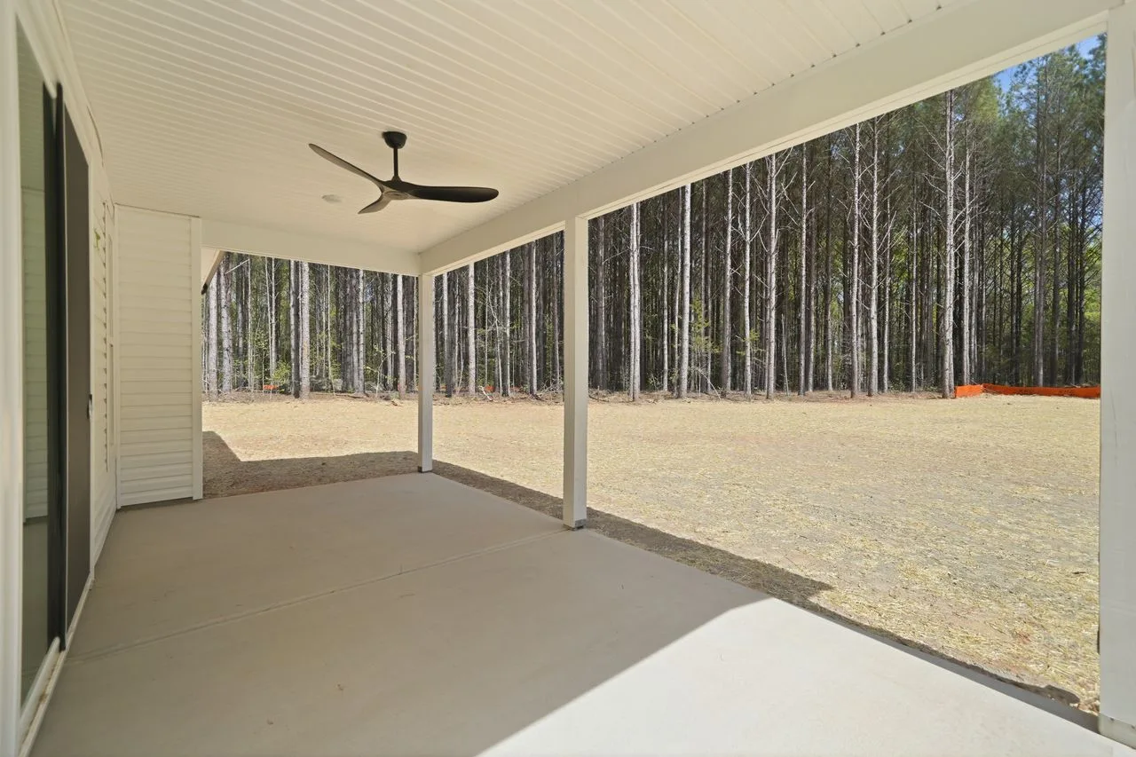 Covered rear porch with ceiling fan overlooking wooded backyard — 1424 Quiver Way, York SC