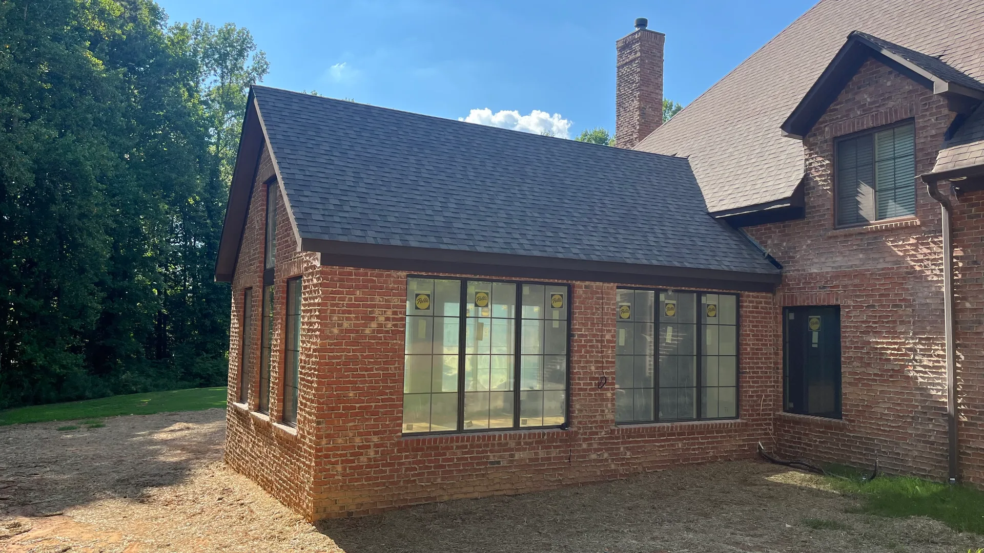 Side view of completed brick addition — new roofline and Pella windows, York County SC