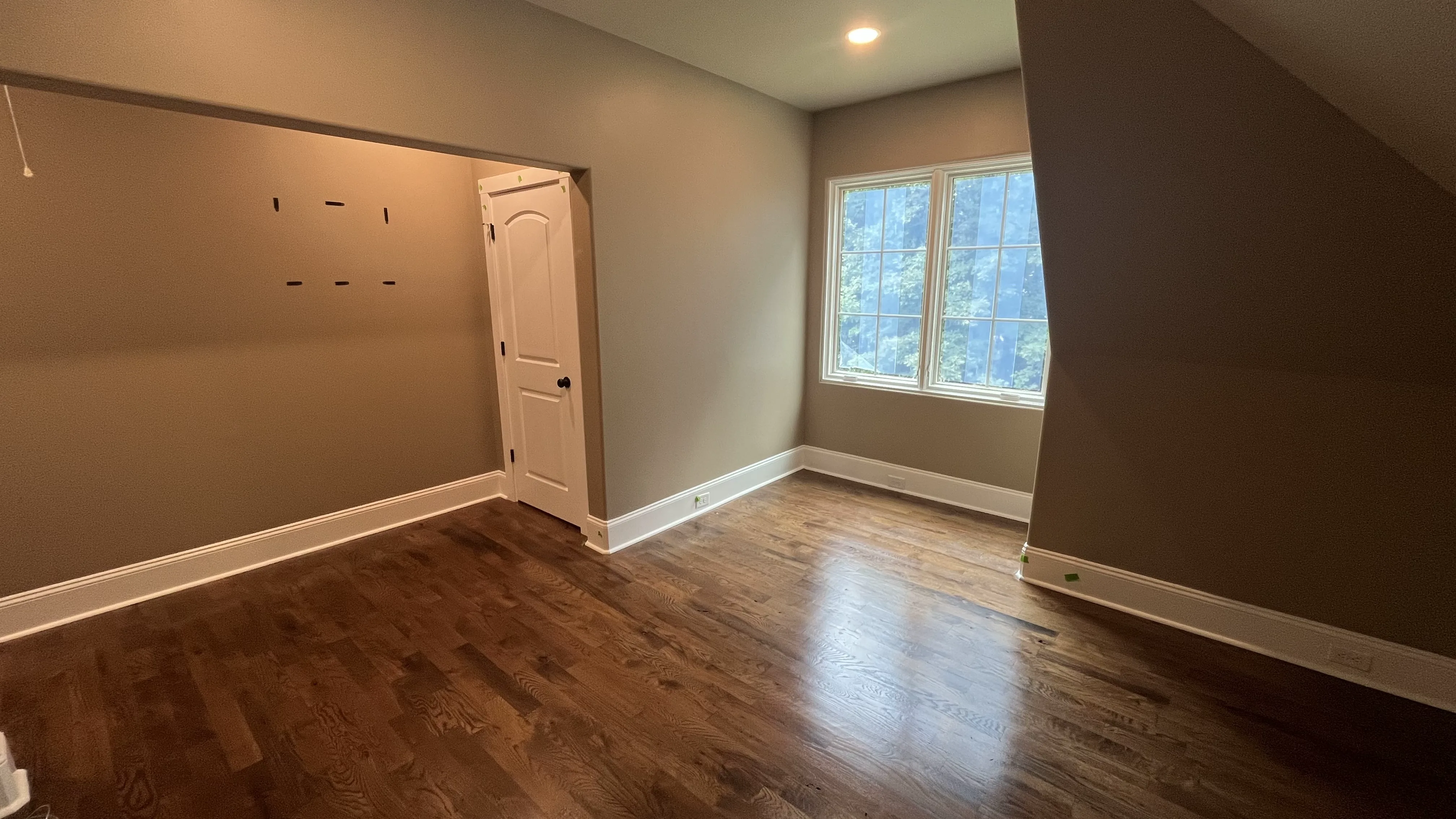 Upper-level bedroom with hardwood floors and sloped ceiling created by dormer addition — York County SC